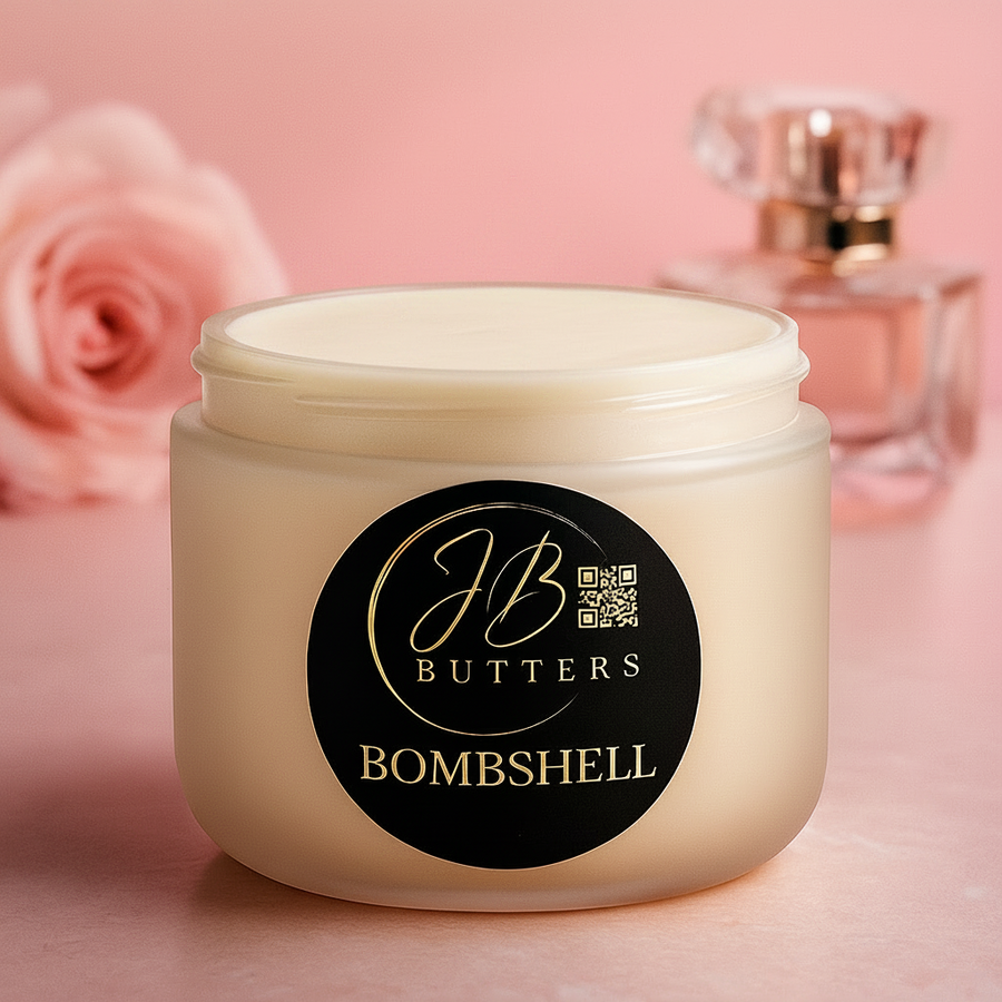 Jar of JB Butters Bombshell cream with a pink rose and perfume bottle in the background