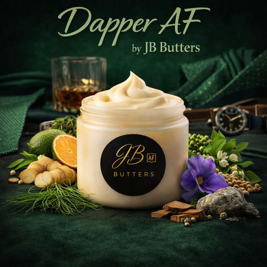 Jar of JB Butters product with greenery and a glass of whiskey on a dark surface, featuring the brand 'Dapper AF by JB Butters'.