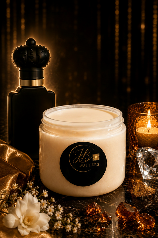 Jar of cream with a black label, next to a perfume bottle and lit candle on a dark background