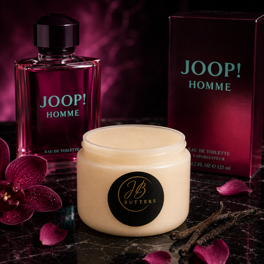 A jar of JOOP! HOMME body butter by JB Butters in the center, flanked by a JOOP! HOMME perfume bottle and box in the background, with purple orchid flowers and vanilla pods on a dark marble surface.