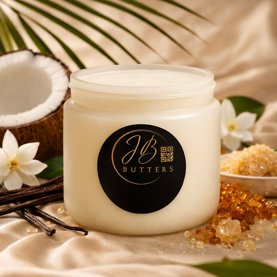 Jar of cream with JB Butters logo surrounded by coconut, vanilla beans, and flowers on a textured surface.